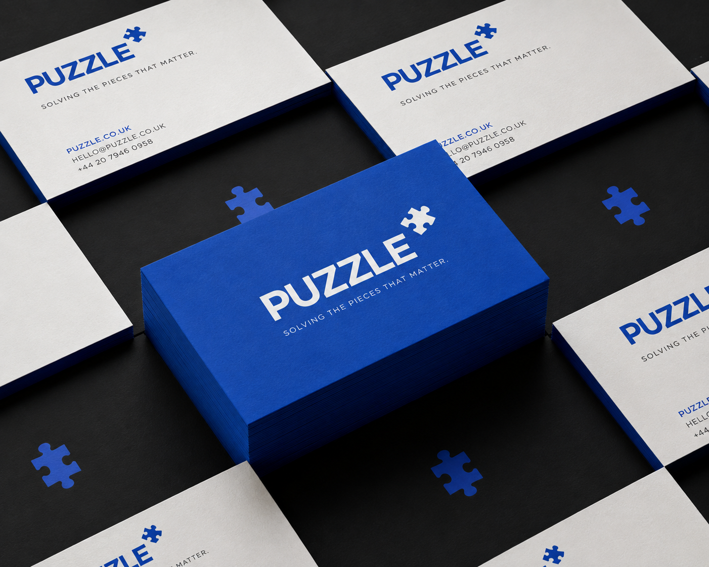 Puzzle — business cards and a brand box in blue and white, the puzzle-piece mark repeating across the set